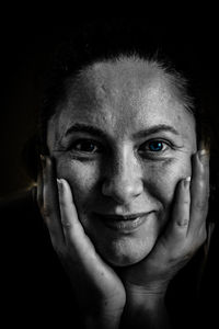 Portrait of mid adult woman against black background