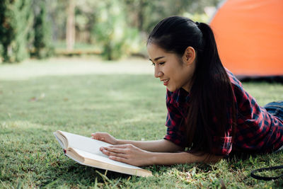 Side view of woman sitting on grass