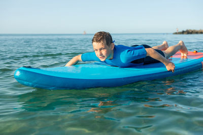 Portrait of boy in sea against sky