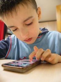 Using technology,social media boy child playing a game on a smartphone, close-up