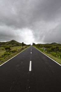 Empty road along countryside landscape