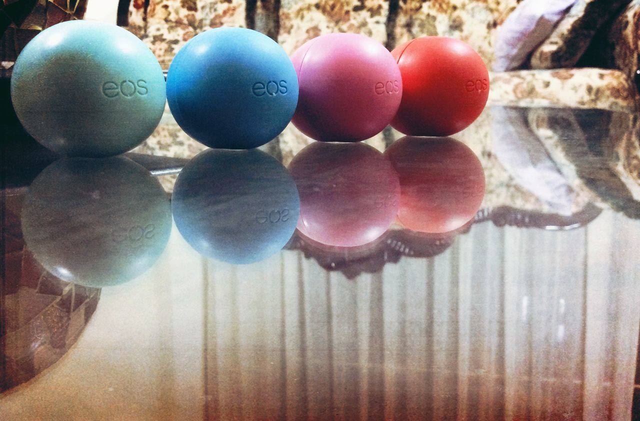 close-up, indoors, still life, large group of objects, multi colored, wood - material, hanging, decoration, balloon, focus on foreground, celebration, sphere, table, fruit, circle, food and drink, no people, abundance, tradition, variation