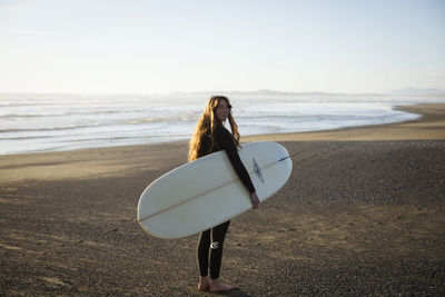 Surfer girl on beach near tofino