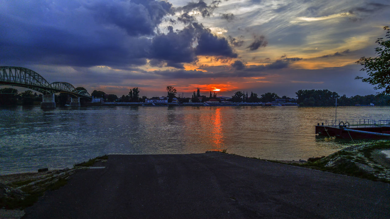 SCENIC VIEW OF RIVER BY CITY AGAINST SKY DURING SUNSET