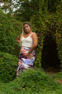 Portrait of beautiful young woman against plants