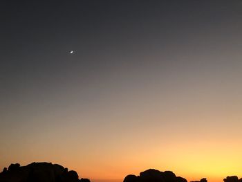 Silhouette landscape against sky at night