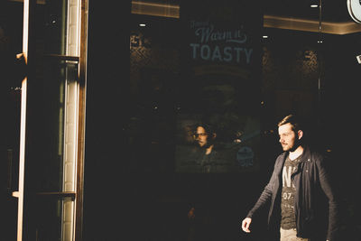 Young man walking by store