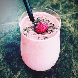 Close-up of pink smoothie in glass on counter