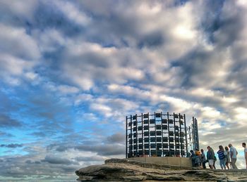 Silhouette of people against cloudy sky