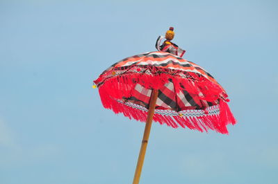 Low angle view of red umbrella against clear sky