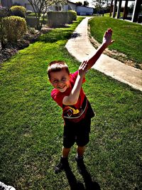 Portrait of smiling boy standing on grass