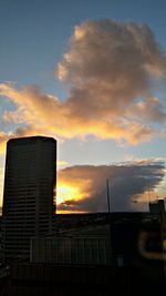 Low angle view of buildings against cloudy sky