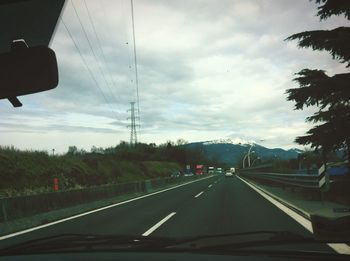 Empty road against cloudy sky