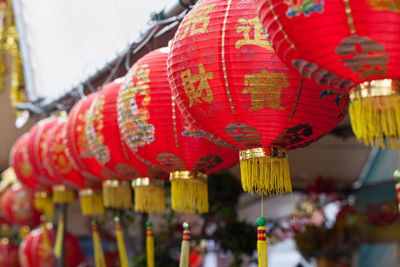 Close-up of red paper lanterns hanging in row for sale at market
