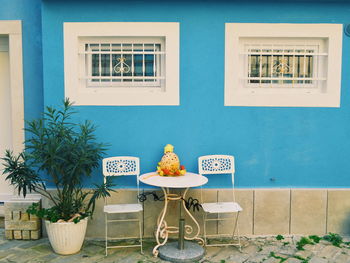 Decoration on table amidst chairs against house