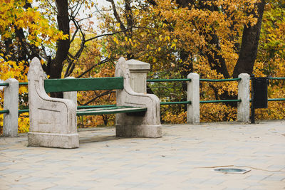 Park bench by footpath during autumn