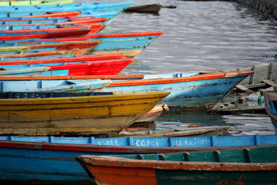 Wooden boats moored in row on lake