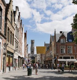 People walking on street in city against sky