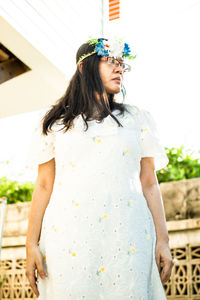 Woman looking away while standing against blurred background