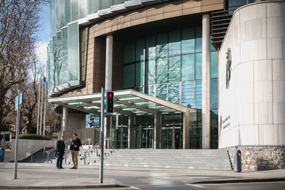 People walking on street by modern buildings