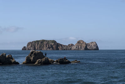 Scenic view of rocks in sea against sky