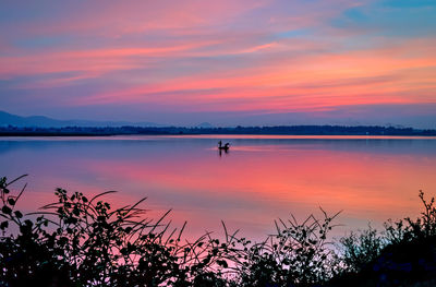 Scenic view of lake against orange sky