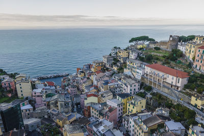 High angle view of townscape by sea against sky