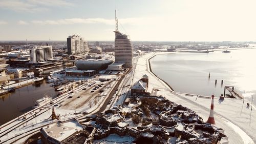 High angle view of buildings by sea against sky