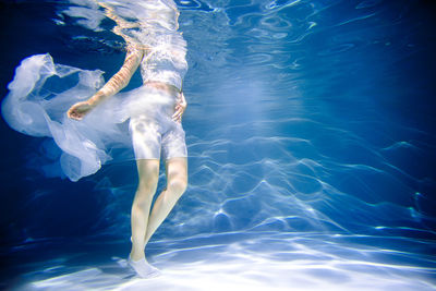 Low section of woman swimming in pool