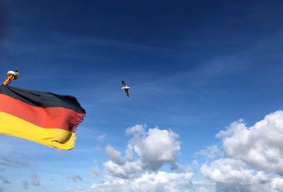 Low angle view of flag flying in sky