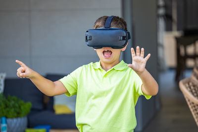 Excited little kid using virtual reality glasses