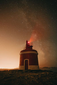 Lighthouse against sky at night