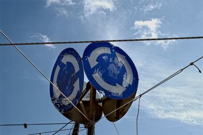 Low angle view of sign against blue sky