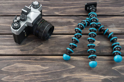 High angle view of old camera with tripod on table