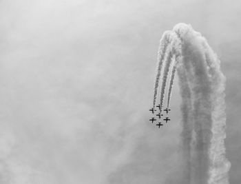 Low angle view of airshow against sky