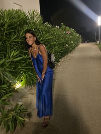 Young woman standing against plants