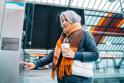 Portrait of young woman standing in train