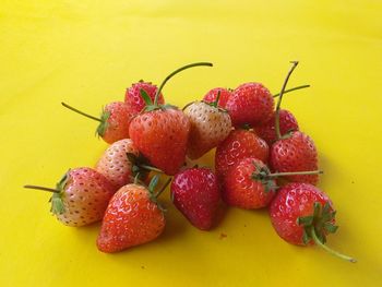 Close-up of strawberries on table against yellow background