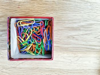 Directly above shot of paper clips in box on table