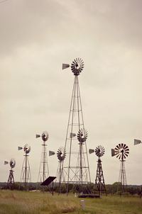 American-style windmills on field against sky