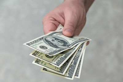 Close-up of hand holding paper against blurred background