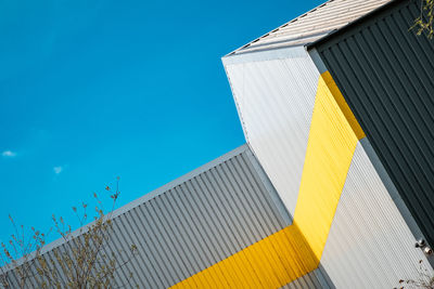 Low angle view of modern buildings against blue sky