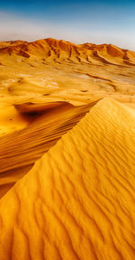 Sand dunes in desert against sky