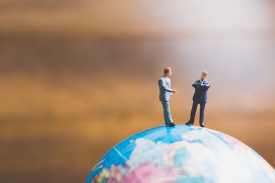 Close-up of entrepreneur figurines on globe