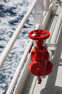 High angle view of red valve by railing on boat