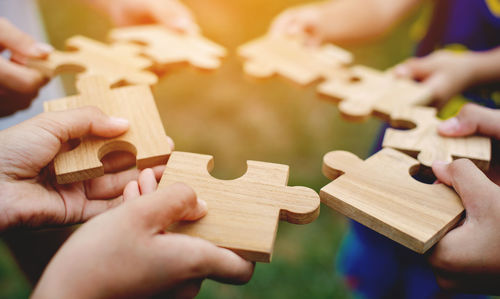 Cropped hand playing with toy blocks on table