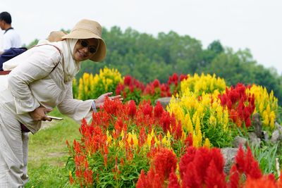 Rear view of man standing by flowering plants