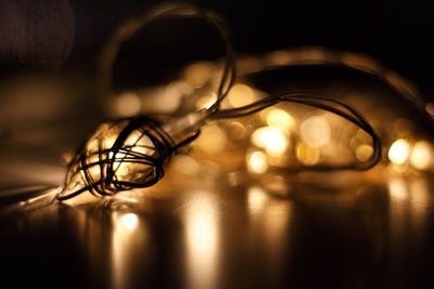 Close-up of illuminated electric lamp on table