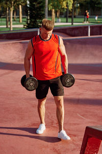 Rear view of man standing with arms raised