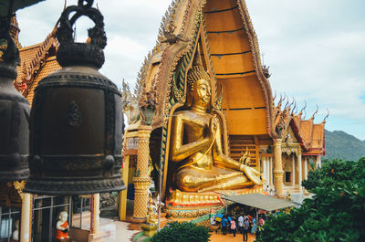 Statue of temple against building and sky